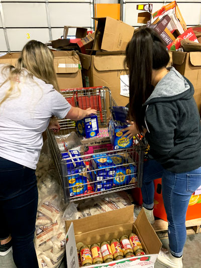 Two women filling a cart with food at the Food Bank of Lincoln