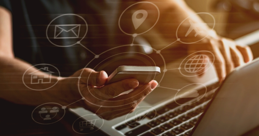 A person holding a phone with icons for multiple data aggregation platforms floating around it to depict listings and reputation management