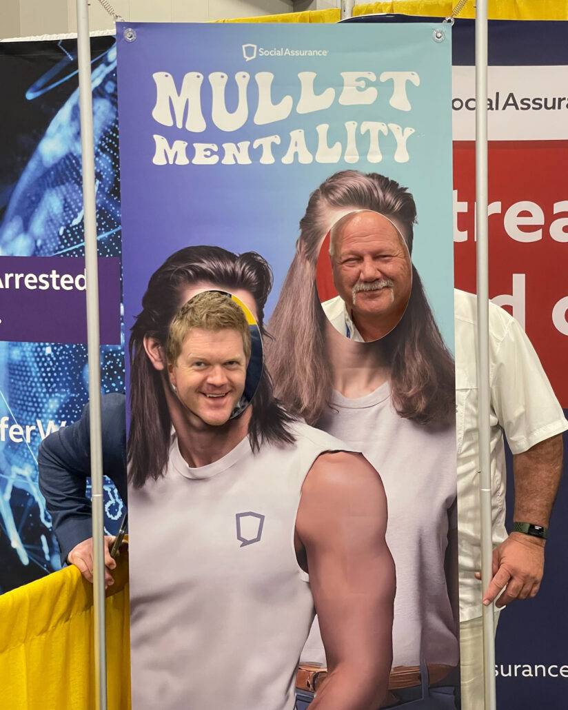 Ben and a man pose at the Social Assurance booth.