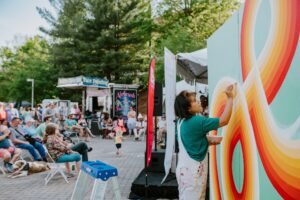 An artist painting a mural at the Dogwood Arts Festival.